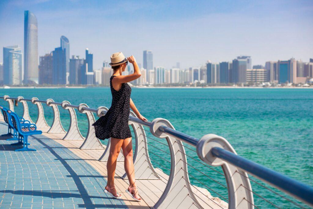 Frau auf einer Promenade mit Blick auf Dubais Skyline.